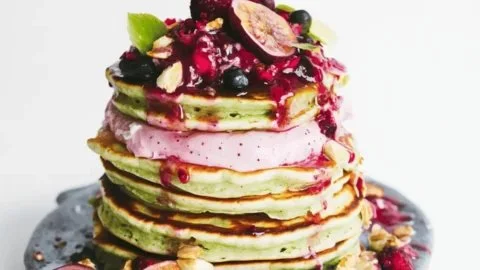 Delicious matcha pancakes with acai cream filling served on a plate