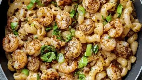 Creamy blackened shrimp cavatappi dish garnished with herbs