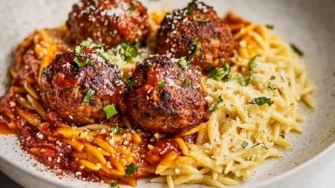 Creamy chicken meatballs served with fresh orzo on a plate