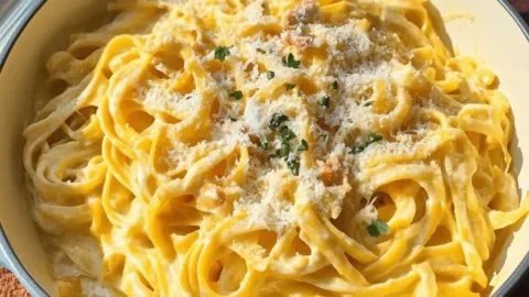 Creamy pumpkin Alfredo pasta garnished with herbs, perfect for fall comfort food.
