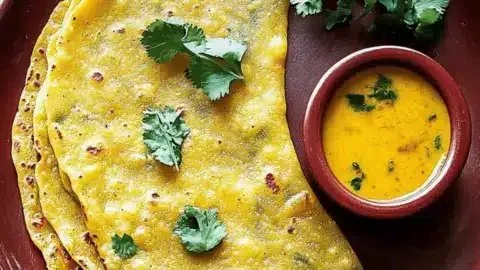 Crispy chickpea pancakes served on a plate with fresh herbs