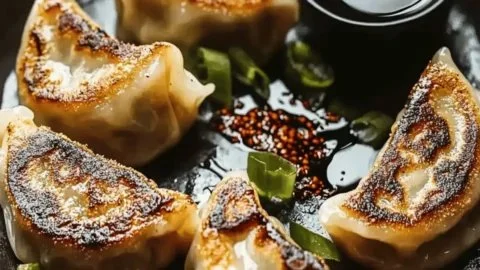 Crispy pan-fried dumplings served with dipping sauce