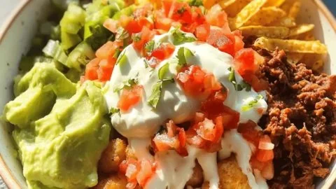 Crispy Tater Tot Taco Bowl topped with fresh ingredients and cheese