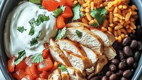 Cuban Chicken and Black Bean Rice Bowl topped with fresh herbs and lime.