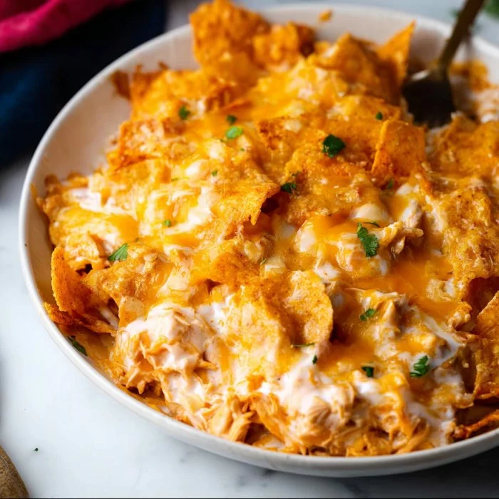 Doritos cheesy chicken casserole served in a baking dish, garnished with green onions