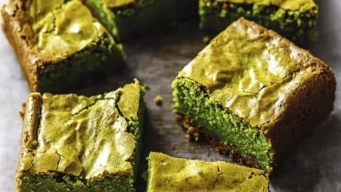 Fudgy matcha brownies topped with chocolate drizzle and green tea powder