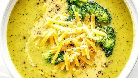 Bowl of healthy broccoli cheese soup garnished with fresh herbs