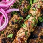Homemade Chicken Kofta Kebabs served on a plate with fresh herbs and spices.