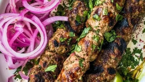 Homemade Chicken Kofta Kebabs served on a plate with fresh herbs and spices.