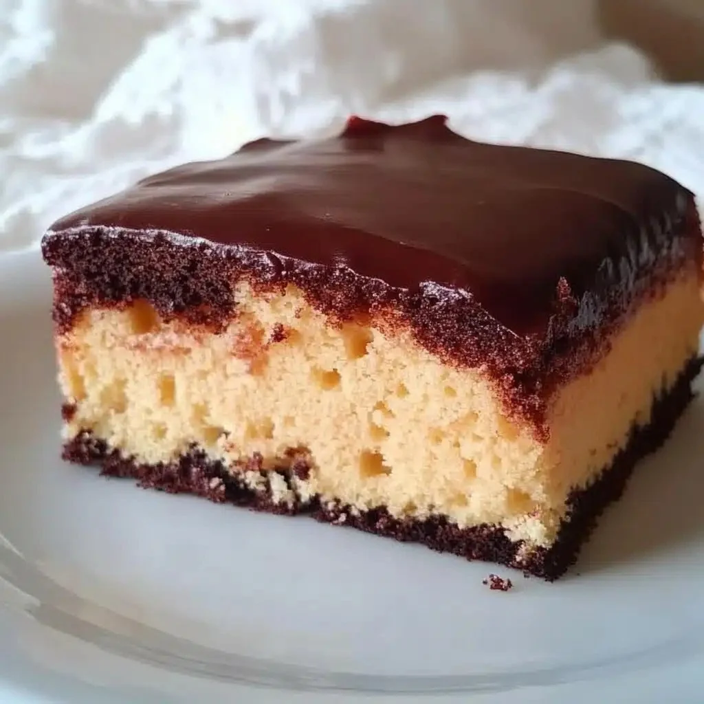 Delicious Boston Cream Poke Cake with chocolate frosting and custard filling