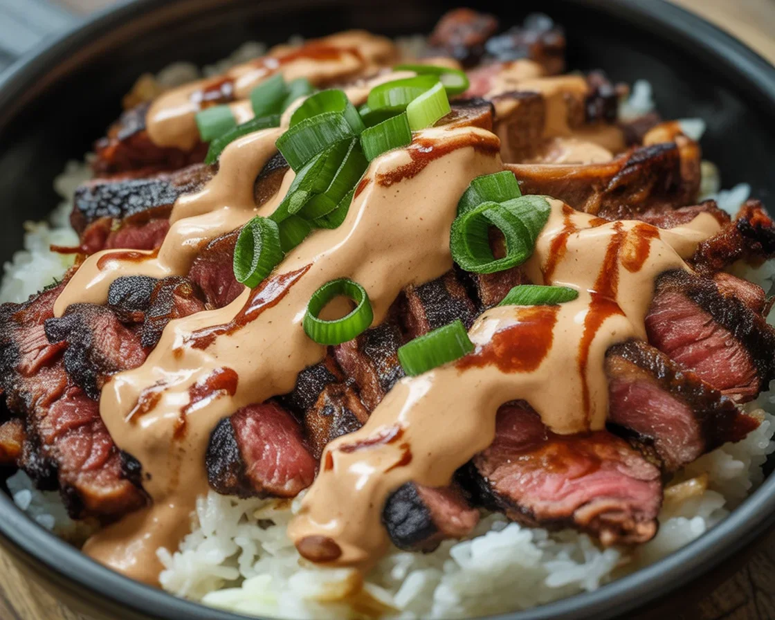 Delicious Korean BBQ Steak Rice Bowls topped with spicy cream sauce and fresh vegetables.