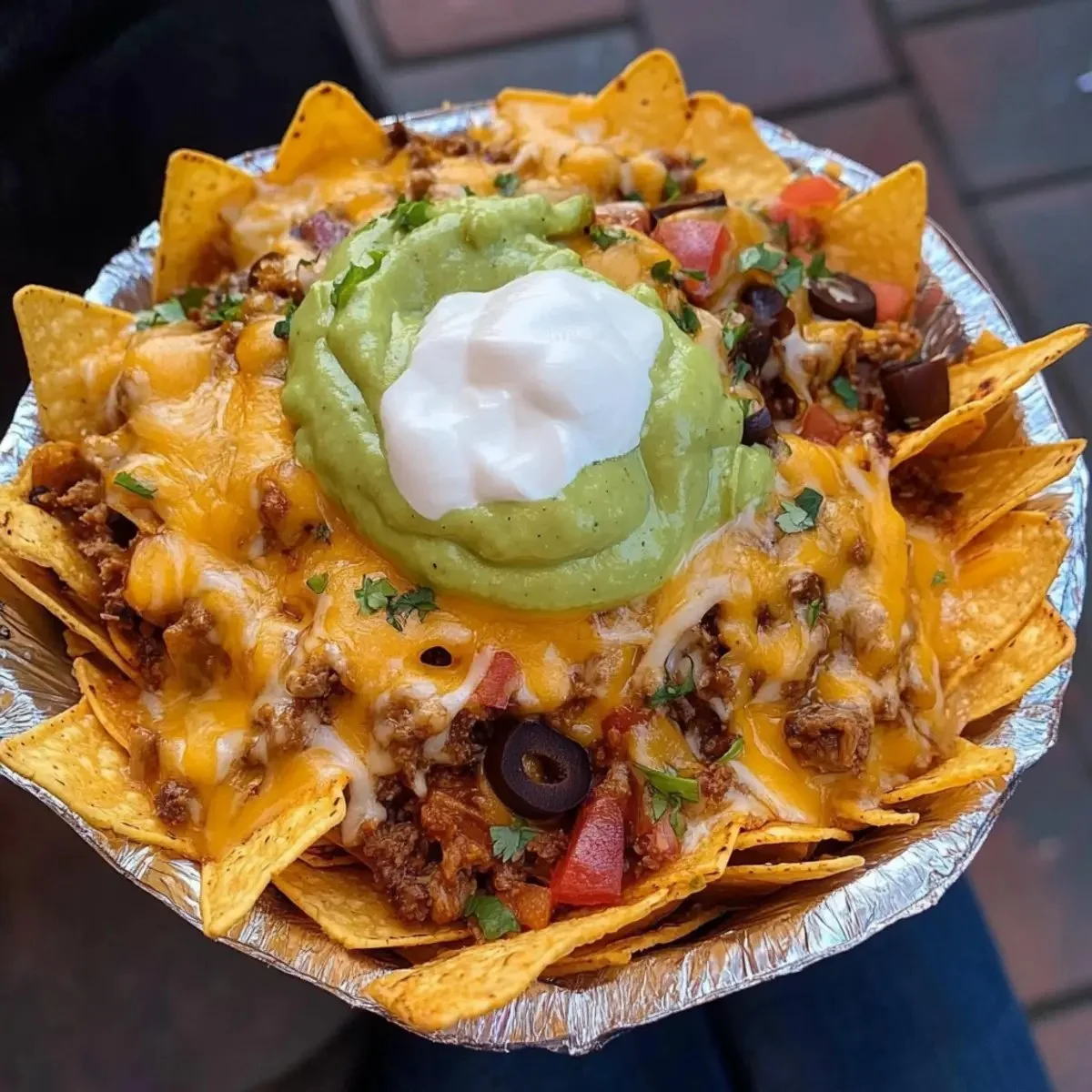 Plate of irresistibly cheesy nachos topped with fresh ingredients