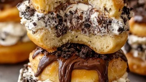 Killer Oreo Cheesecake Donut Burgers topped with drizzled chocolate and Oreo crumbles