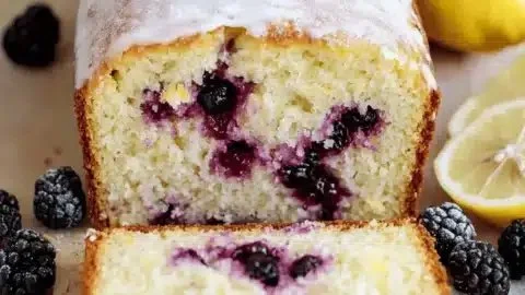Lemon Blackberry Loaf with fresh blackberries and lemon slices on a wooden table