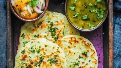 Delicious Onion Uttapam served with chutney and sambar.