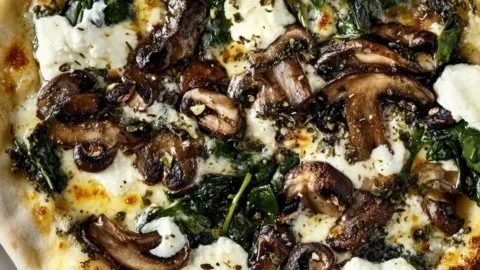 Savory garlic mushroom spinach pizza with melted cheese and fresh ingredients