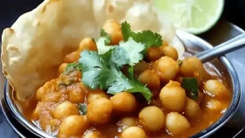 Delicious spicy Chana Bhatura served with onion and lemon