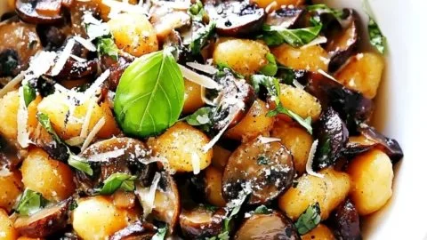 Toasted gnocchi with mushrooms and basil served on a plate