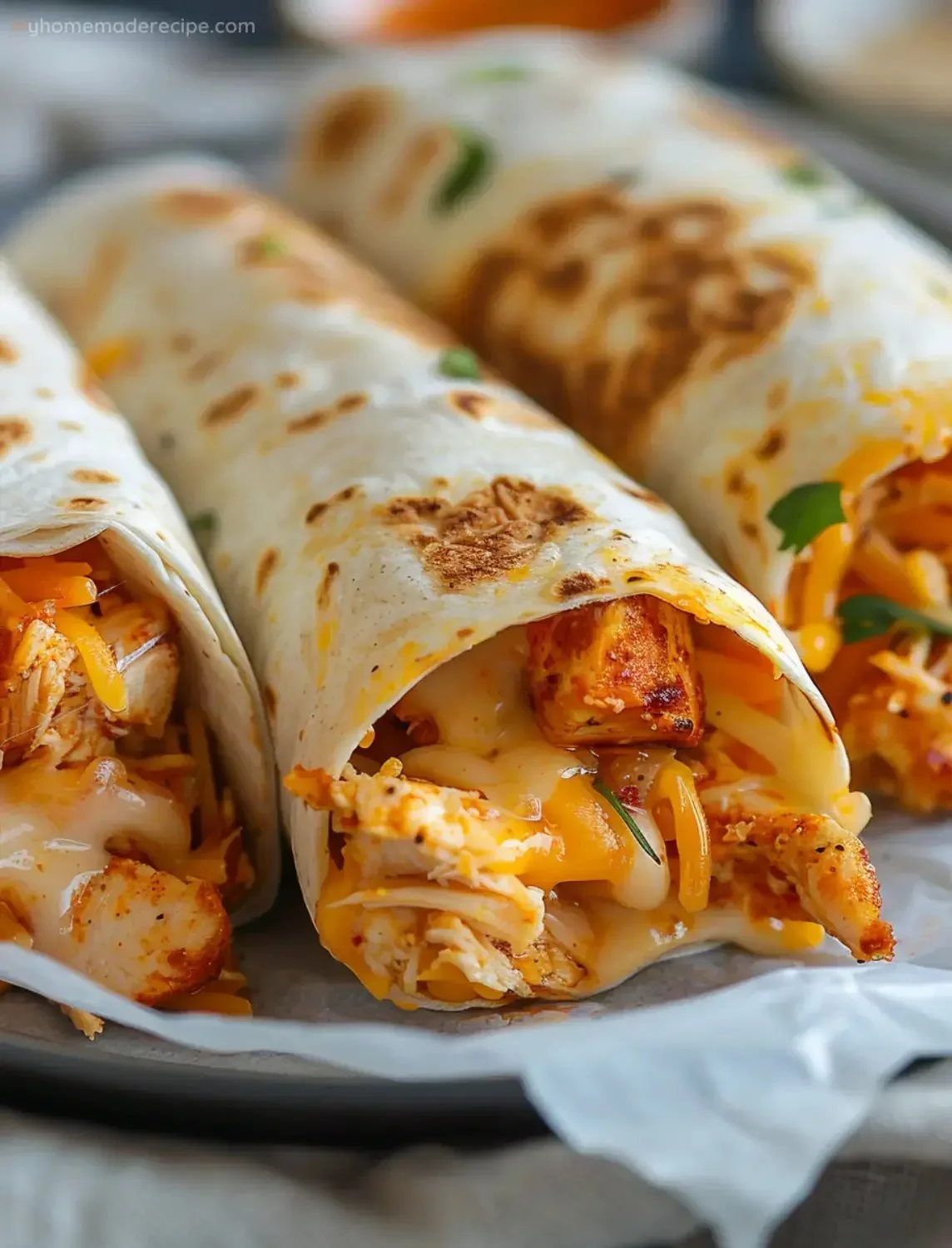 Crispy air fryer chicken wraps served on a plate with fresh veggies