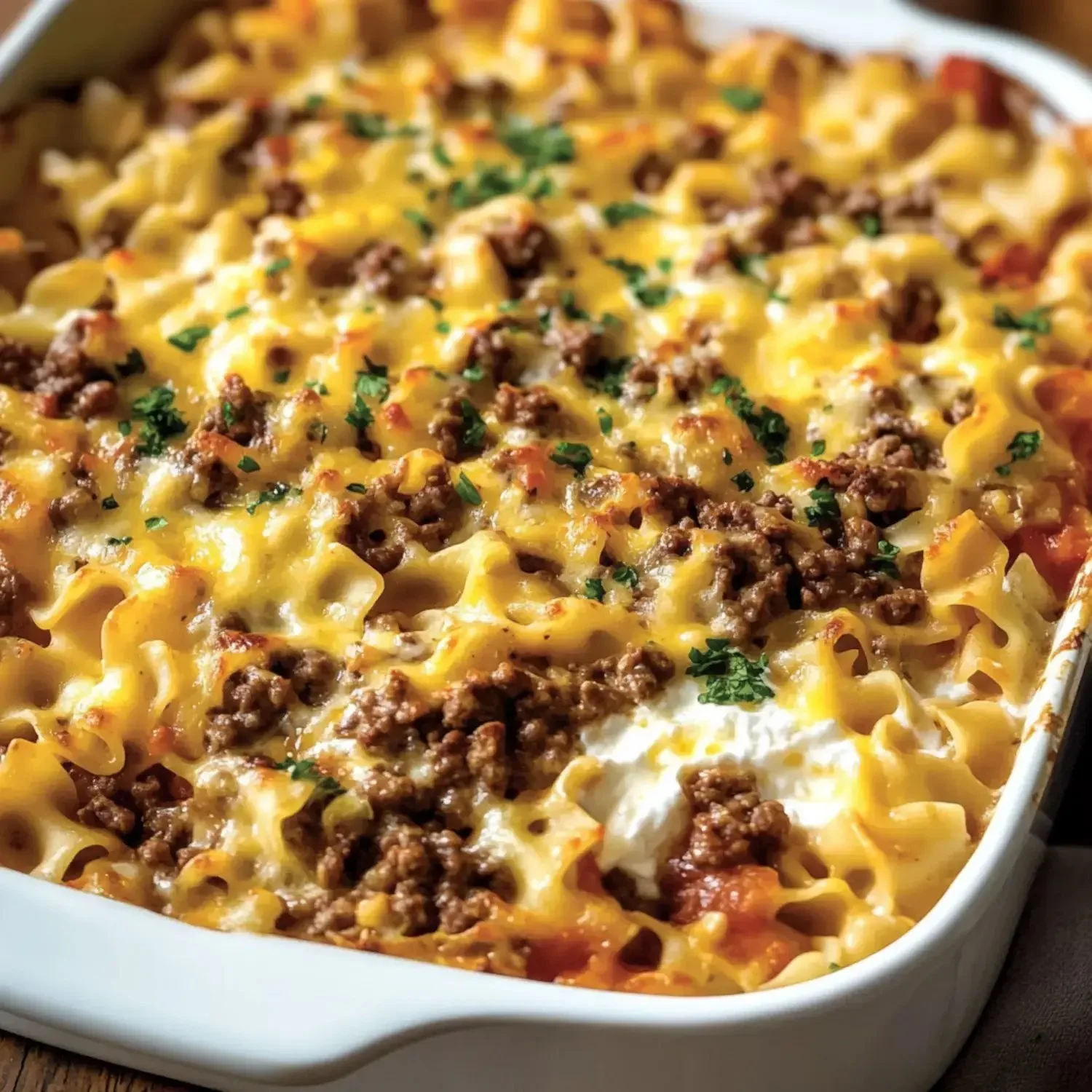 A delicious serving of Amish Hamburger Casserole topped with cheese and herbs