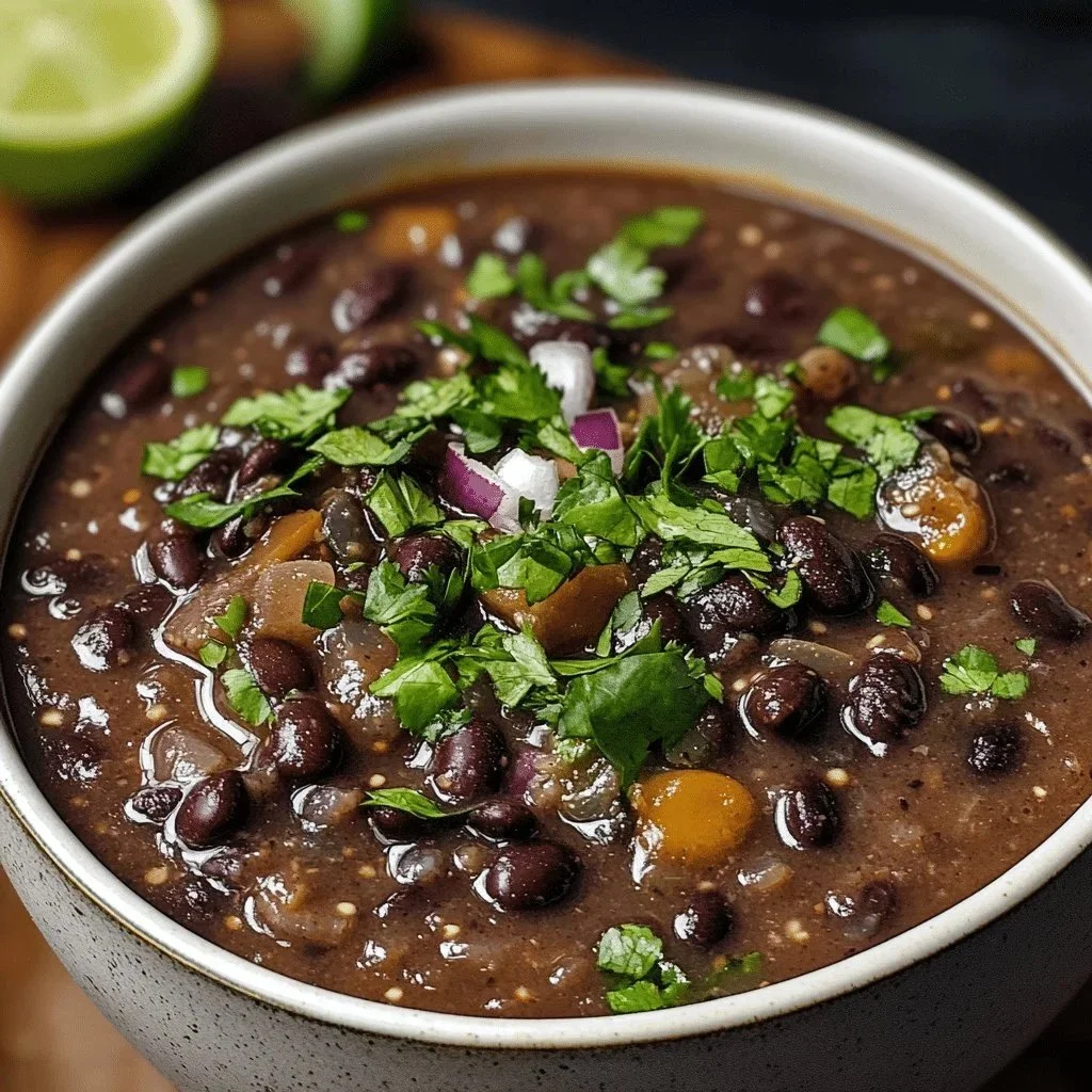 A bowl of delicious black bean soup topped with fresh cilantro and lime.