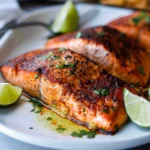 A plate of perfectly cooked Blackened Salmon with spices and herbs.