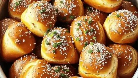 Delicious soft pretzel bites served with dipping sauce on a wooden board.