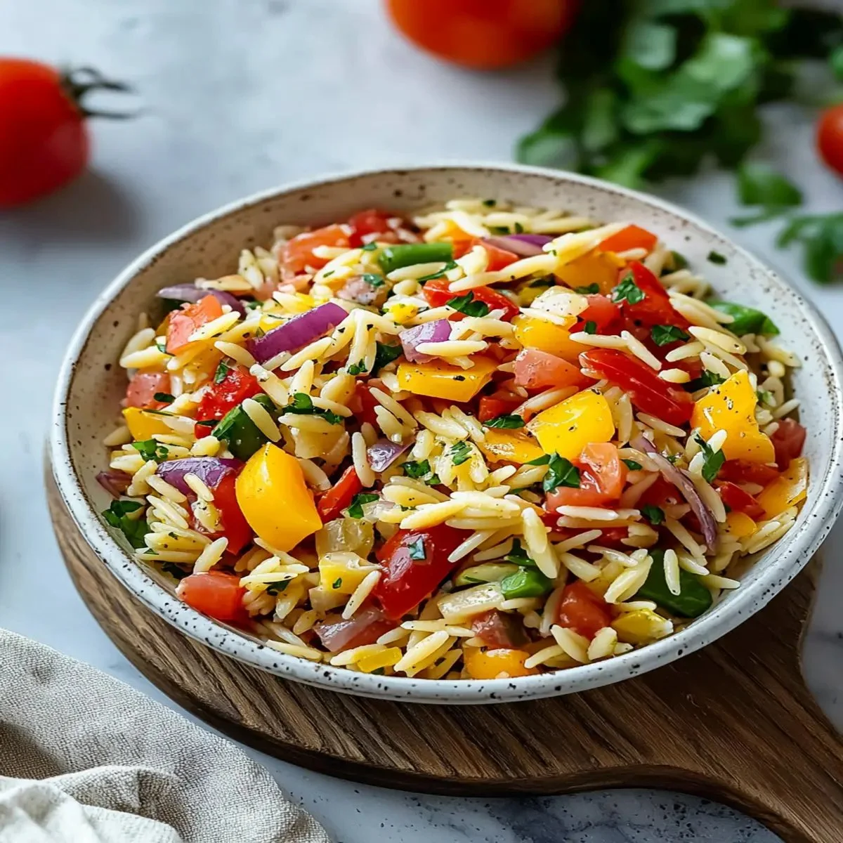 Colorful bowl of easy rainbow orzo salad with fresh vegetables and herbs.