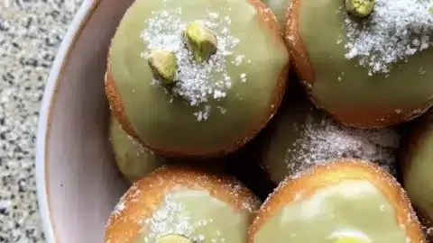 Fluffy pistachio doughnuts with a light glaze and crushed pistachio topping.