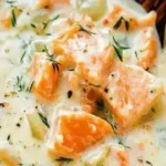 Bowl of delicious salmon chowder soup garnished with herbs and served warm