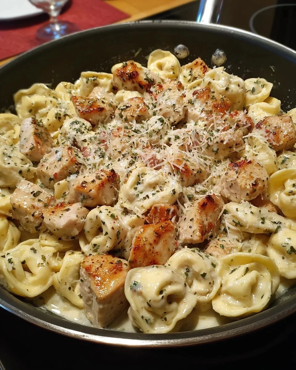 Delicious bowl of Italian Parmesan Chicken Tortellini garnished with herbs.