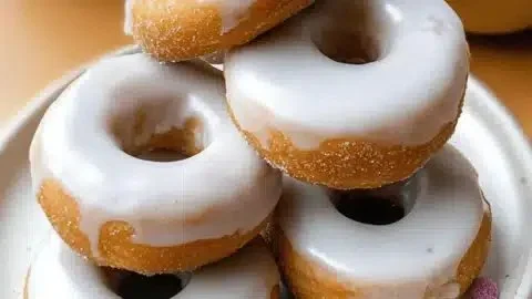 No bake vegan protein donuts with a glossy glaze on a white plate