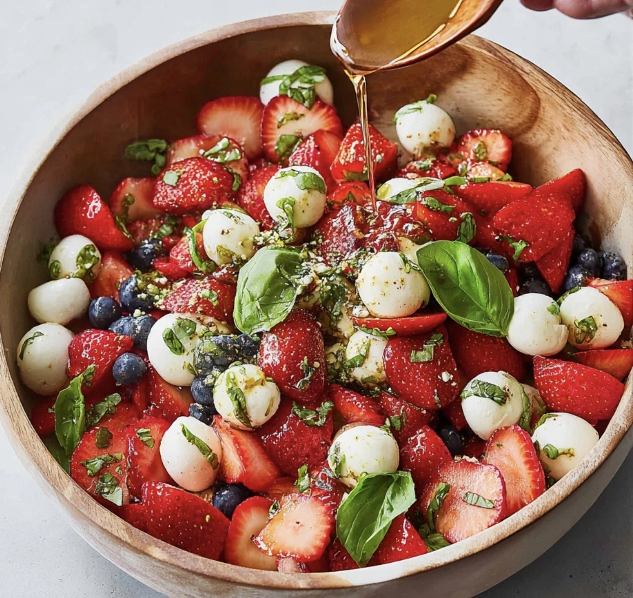 Strawberry Caprese Salad with mozzarella and basil served on a plate