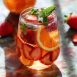 A refreshing glass of Strawberry White Wine Sangria garnished with fresh strawberries.