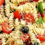 Colorful bowl of best ever Italian pasta salad with fresh vegetables and dressing