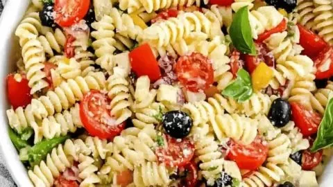 Colorful bowl of best ever Italian pasta salad with fresh vegetables and dressing