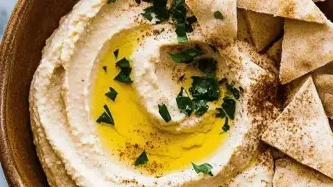 Delicious homemade hummus served with fresh vegetables and pita bread