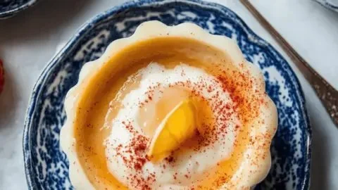 Bowl of creamy Rømmegrøt topped with cinnamon and sugar, a traditional Norwegian dish.