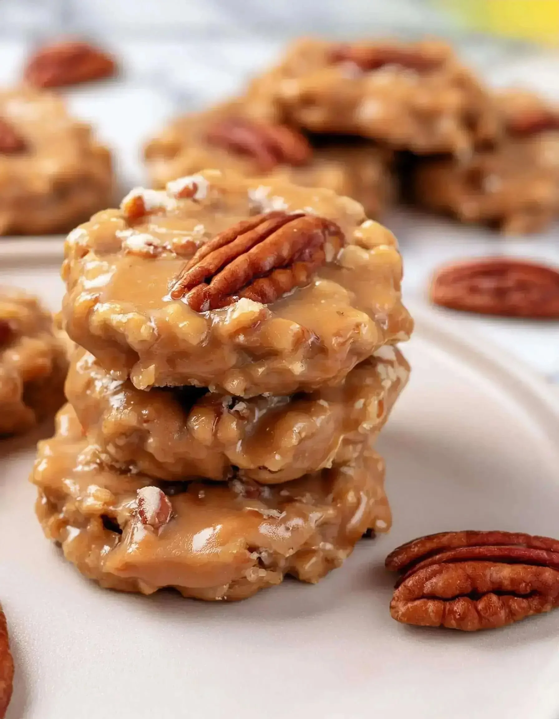 No bake coconut pecan cookies topped with praline glaze on a plate