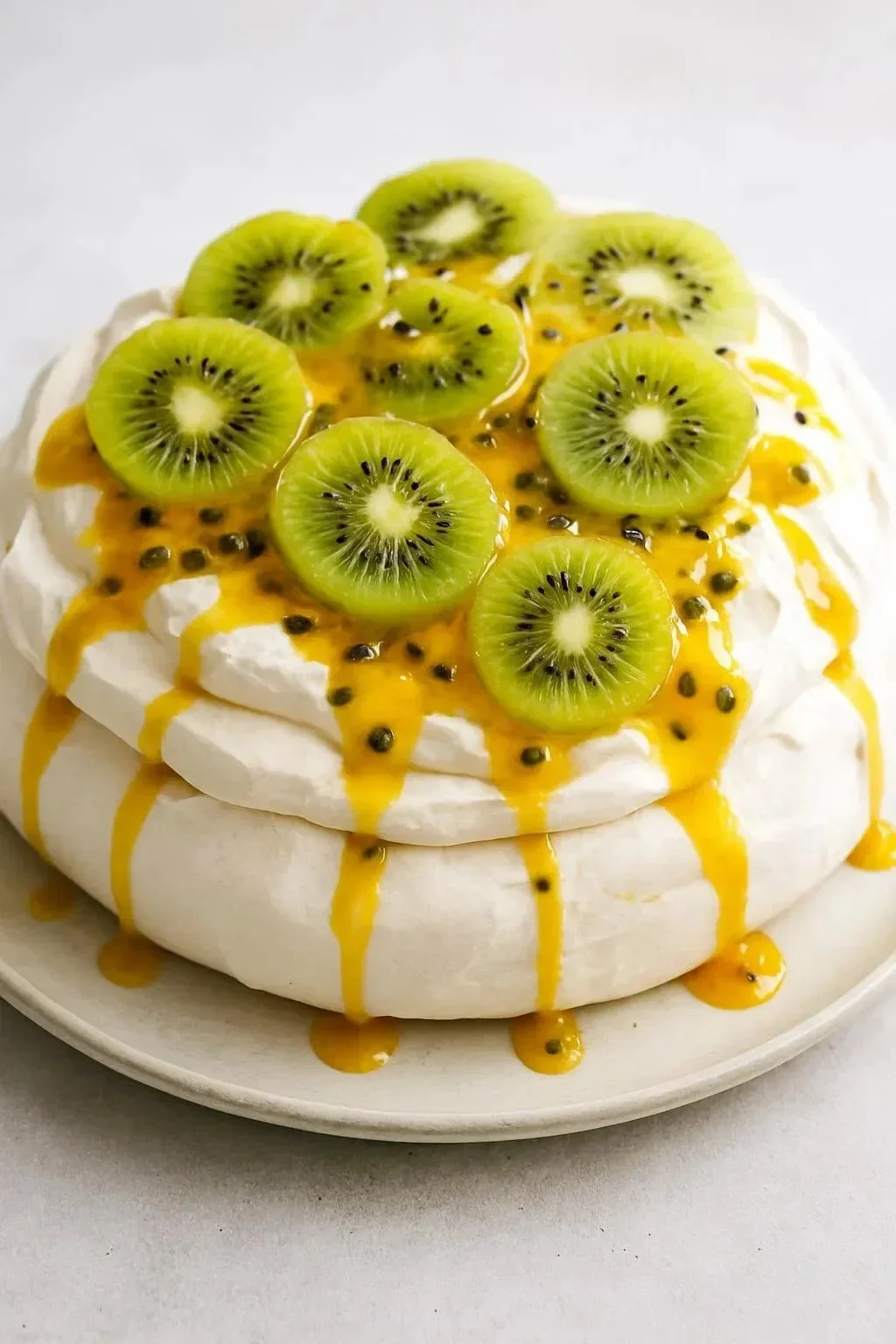 Delicious Kiwi Passionfruit Pavlova dessert topped with fresh kiwi and passionfruit.