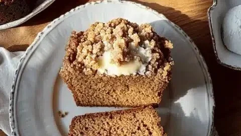 Slice of melt-in-your-mouth brown butter pumpkin streusel bread topped with crumb topping.