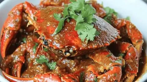 Delicious plate of Singaporean Chilli Crab garnished with herbs and spices
