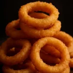 Plate of crispy buttermilk pancake batter onion rings garnished with herbs