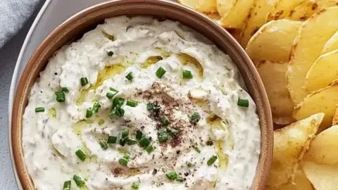Homemade French onion dip served with fresh vegetables and crackers