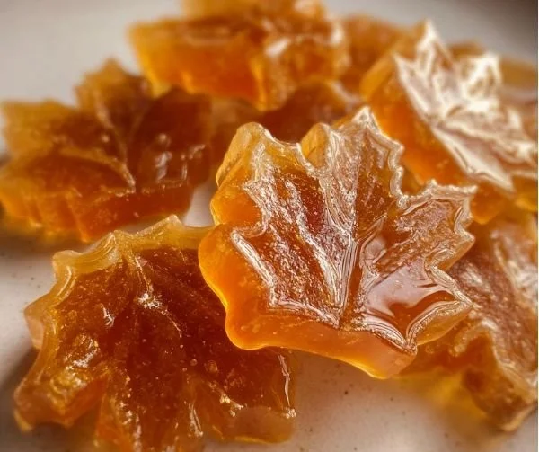 Homemade maple syrup candy with a golden brown appearance on a wooden table