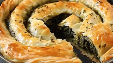 Flaky spanakopita spiral, a delicious Greek snack filled with spinach and feta cheese.