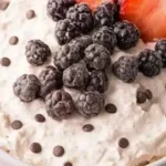 Delicious cheesecake dip served in a bowl with fruit and crackers for dipping